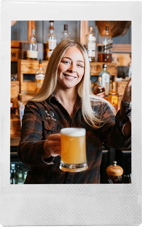 a woman is holding a glass of beer